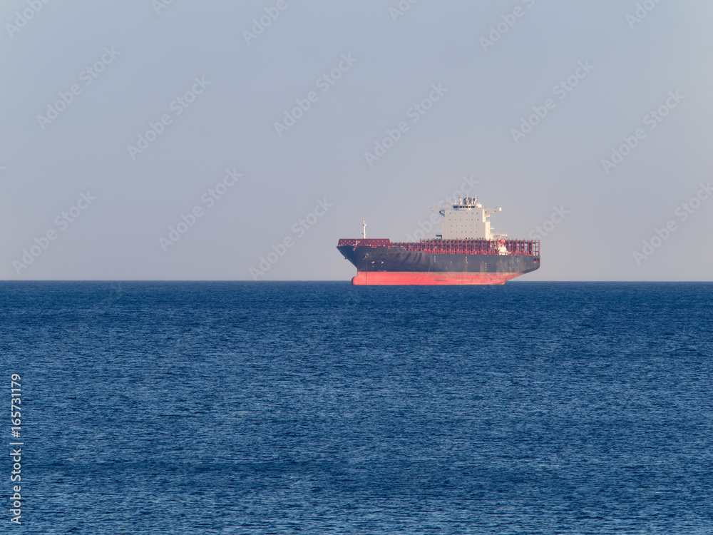 Container cargo ship anchored off the harbor awaiting loading Container cargo ship anchored off the harbor awaiting loading
