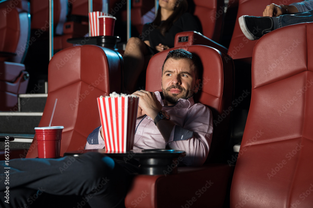 Fototapeta premium Scared man watching a horror movie