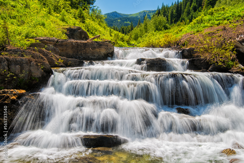 A waterfall pours down a mountain valley in Montana