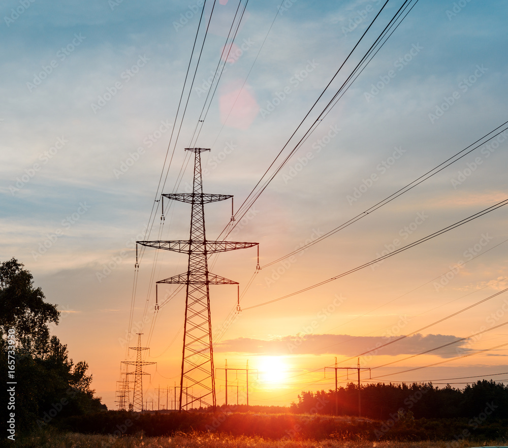 high-voltage power lines at sunset. electricity distribution station