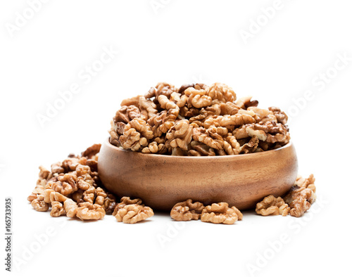 Walnut kernels in a wooden bowl isolated on white