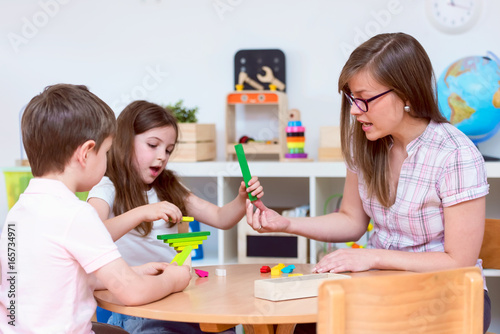 Preschool Teacher and Kids Playing with Wooden Toy Building Blocks