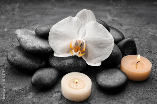 Composition with beautiful white orchid and stones on grey background