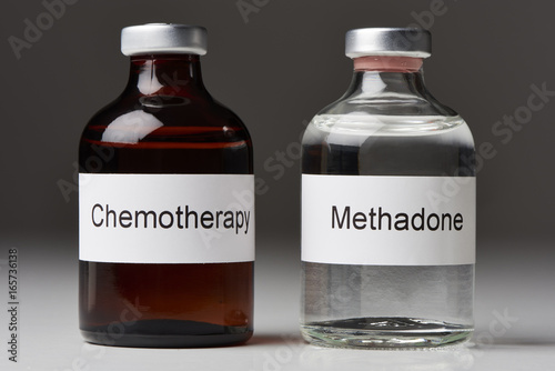 (English label / in transverse format) An ampoule of methadone and a chemotherapy stand on white surface against gray background (English label / in transverse format) photo