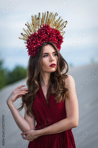 Beautiful girl in a red dress on the beach. Concept of femininity, harmony. photo