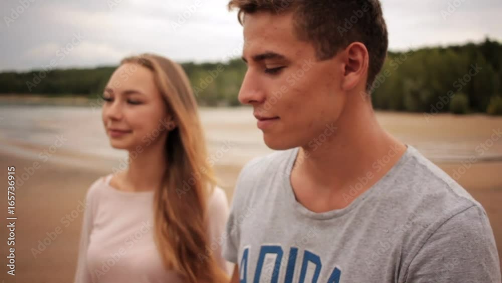 Couple in love looking at each other and walk on sea beach Couple in love looking at each other and walk on sea beach