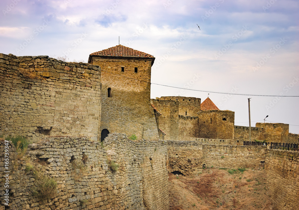 Walls, arched windows and the pointed conical roof of Fortress Akkerman in Bilhorod-Dnistrovskyi, Ukraine. Around the castle is drained the moat, which had previously been water.