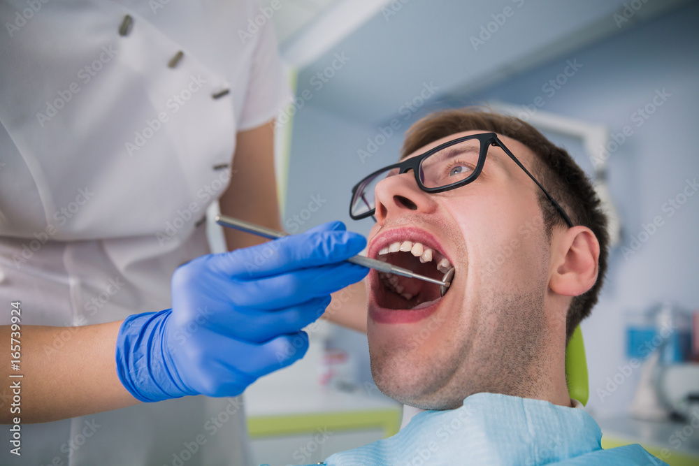 The dentist is working on his patient's teeth The dentist is working on his patient's teeth