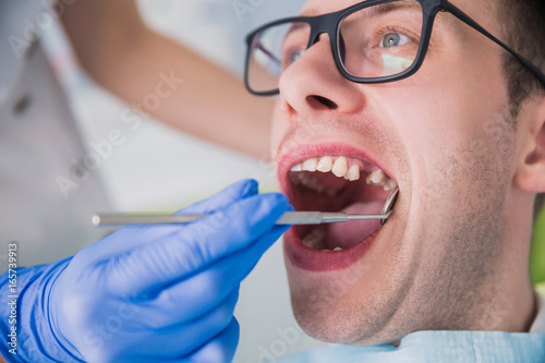  man sitting at a dentist s office at a dentist s office without one tooth