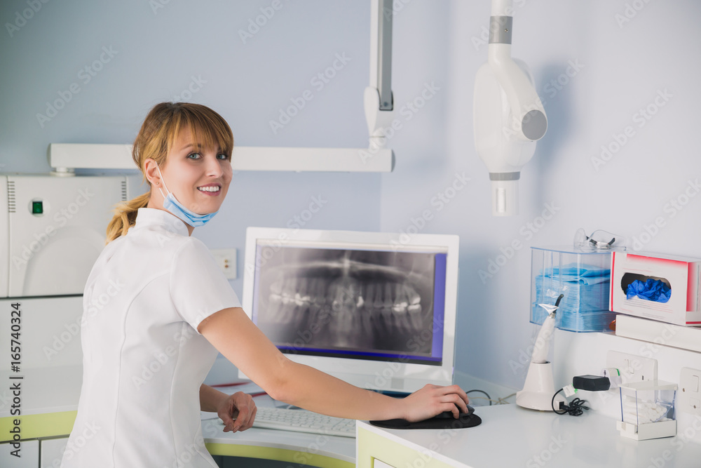 Image of female doctor looking at dental x-ray on the screen. Image of female doctor looking at dental x-ray on the screen.