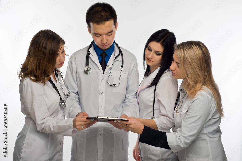 a group of young doctors is discussing something before treatment. Isolated on white background a group of young doctors is discussing something before treatment. Isolated on white background