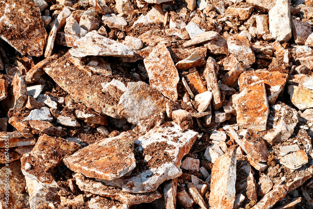 Part of a stone pile of rocks for construction and boulders piled, close up. Brown Granite. A large pile of limestone in quarry. Pile of gravel and construction material.