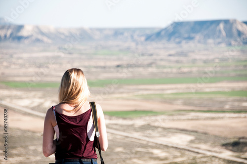 Young woman viewing desert from mountain top, Spain