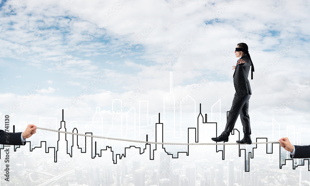 Business concept of risk support and assistance with man balancing on rope Business concept of risk support and assistance with man balancing on rope