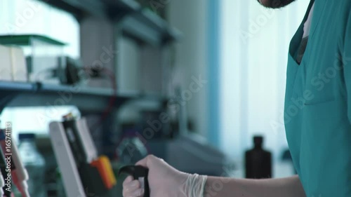 Measuring solutions and reagents: automatic multi-channel dispenser. Equipment for scientific research laboratories and work with reagents. The dispenser is filled with test tubes. photo