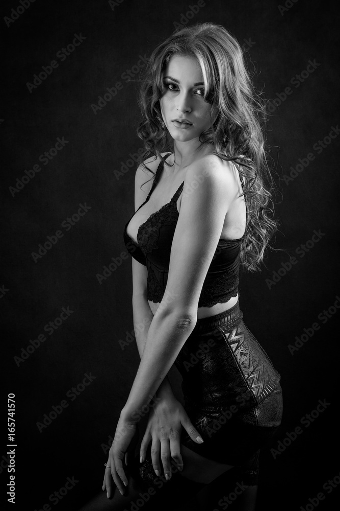 beautiful woman in lingerie posing on black background, monochrome