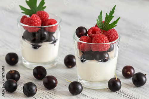 Yogurt with fresh raspberries and currants in the glass.