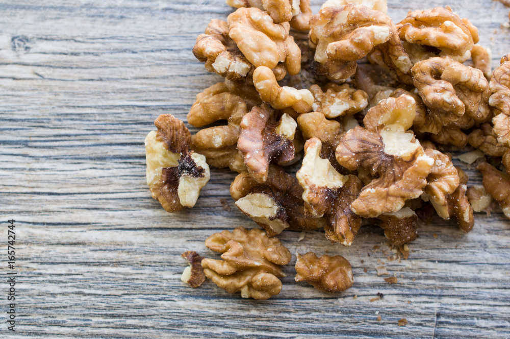 A handful of peeled walnuts on a gray board A handful of peeled walnuts on a gray board