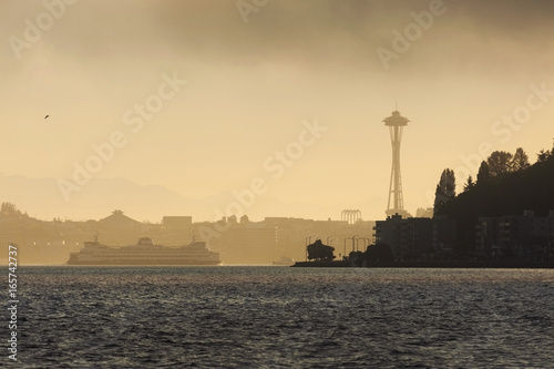 Foggy Seattle Morning. A ferry boat heads to downtown Seattle, Washington passing Alki Point on a foggy summer morning with the Space Needle in the background.