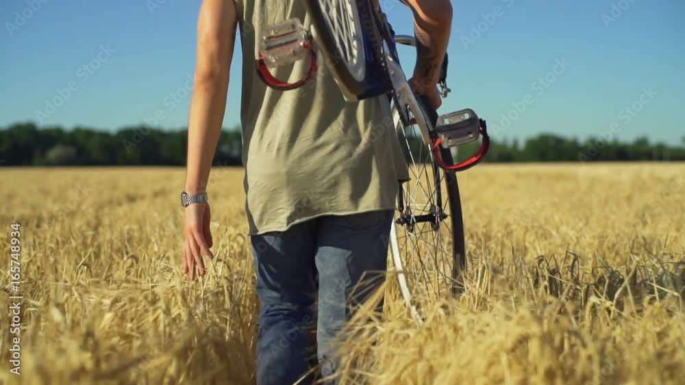 Close up man carry bicycle walk field touch wheat sundown slow motion rapid
