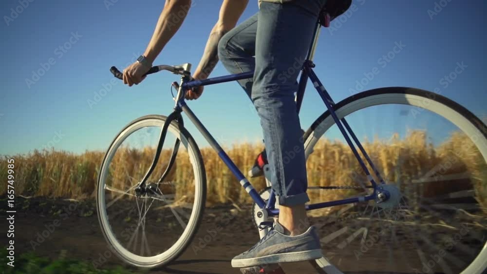 Strong young man riding bicycle near wheat field sundown slow motion rapid Strong young man riding bicycle near wheat field sundown slow motion rapid
