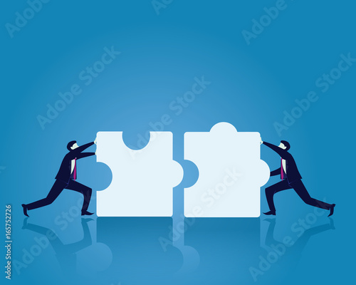 Two Businessman Working To Match Puzzle Together photo