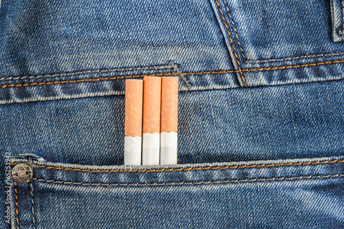 Three cigarettes so close are in the back pocket of blue jeans