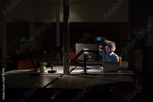 man working on computer in dark office