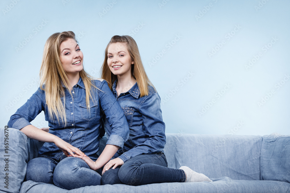 Two happy women friends wearing jeans outfit