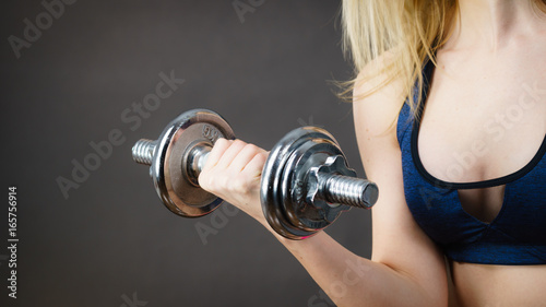 Fit woman lifting dumbbells weights