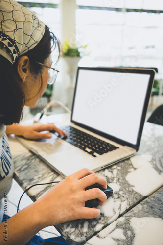 Woman's hands using a laptop in coffee shop.