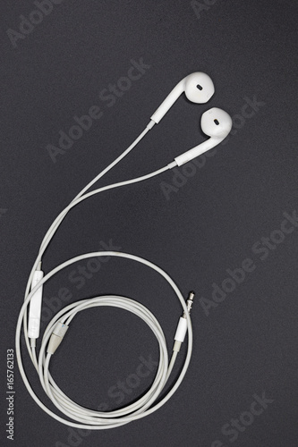 Top view of White Earphones on Black background. Copy space