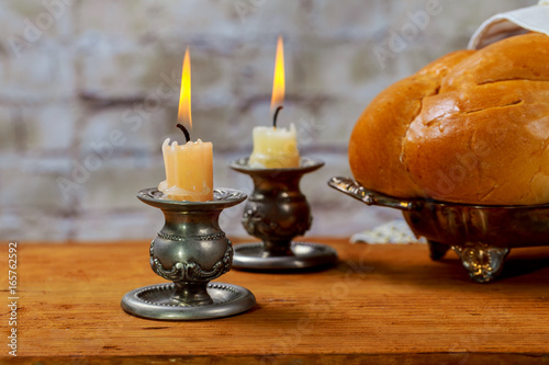 Shabbat with lighted candles, challah bread and wine.