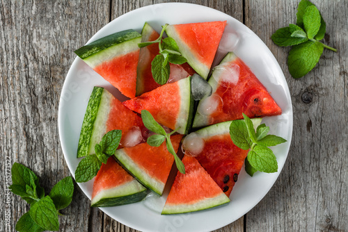 Healthy watermelon slices popsicles on wooden background, overhead