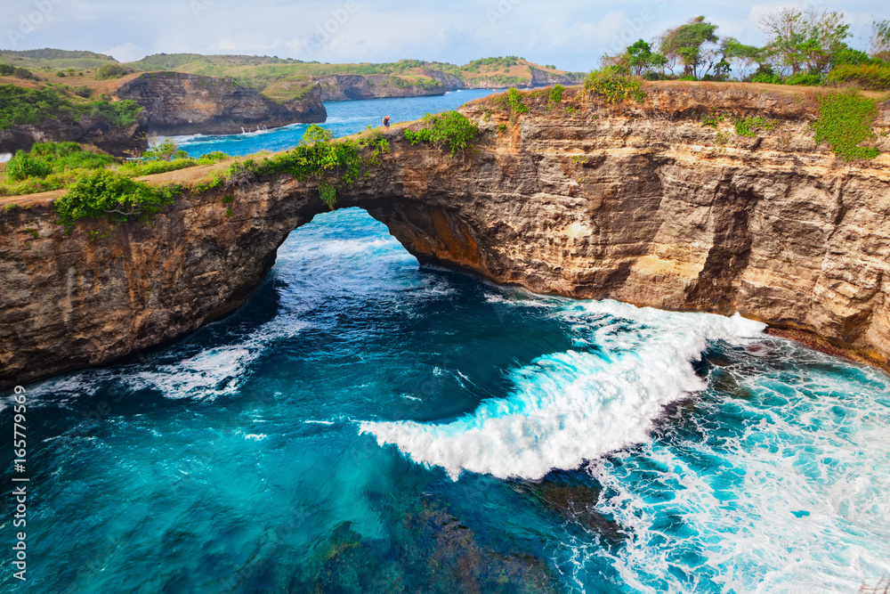 Family lifestyle. Father, mother with children walk and look at natural sea pool Broken Bay. Bali travel destination. Nusa Penida island day tour popular place. Activity on beach holiday with kids.