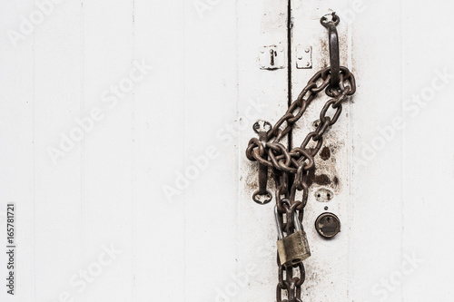 closeup white door lock old grunge chain hard locking with space for text.