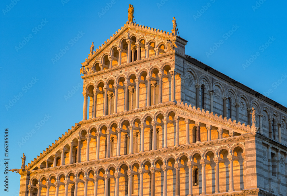 Golden sunlight hit on the facade of Pisa Cathedral in Italy at sunset
