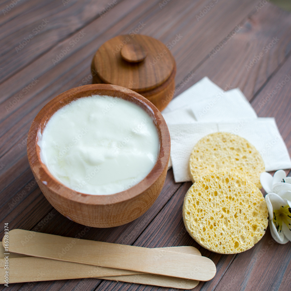 White substance in wooden cup with cinnamon and spices. For hair, face, spa. White substance in wooden cup with cinnamon and spices. For hair, face, spa.