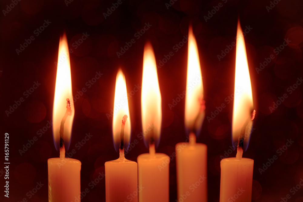 Group still life golden candle light with reflection on red blurred bokeh background. Abstract background for pray or meditation caption and hope concept Group still life golden candle light with reflection on red blurred bokeh background. Abstract background for pray or meditation caption and hope concept