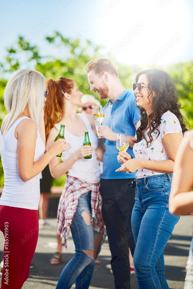 Group of people at outdoor party chatting, drinking and having good time Group of people at outdoor party chatting, drinking and having good time