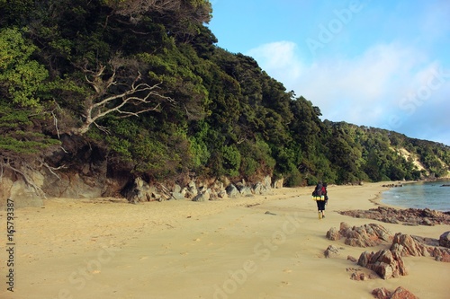 Backpacker walking on the beach.