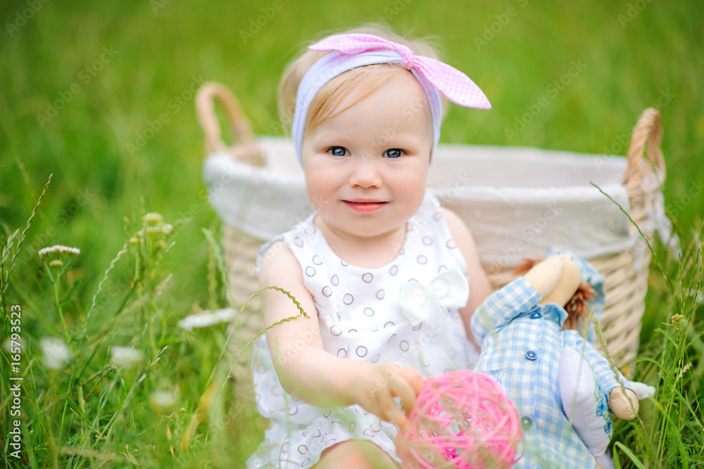 cheerful girl plays sitting on a grass in the beautiful park, looks in the camera and smiles cheerful girl plays sitting on a grass in the beautiful park, looks in the camera and smiles