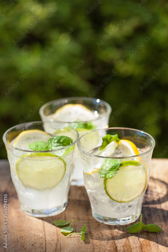 refreshing lemonade drink with mint lime lemon in garden refreshing lemonade drink with mint lime lemon in garden