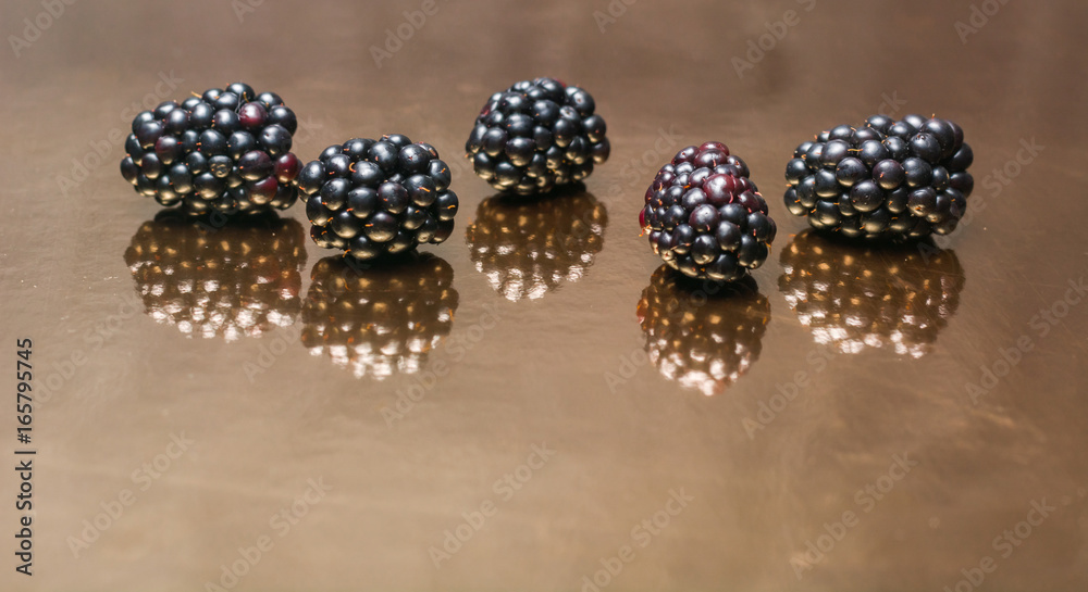 Blackberry berries on a mirror reflecting background. Blackberry berries on a mirror reflecting background.