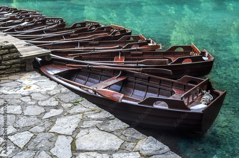 Wooden boats are parked by the shore.