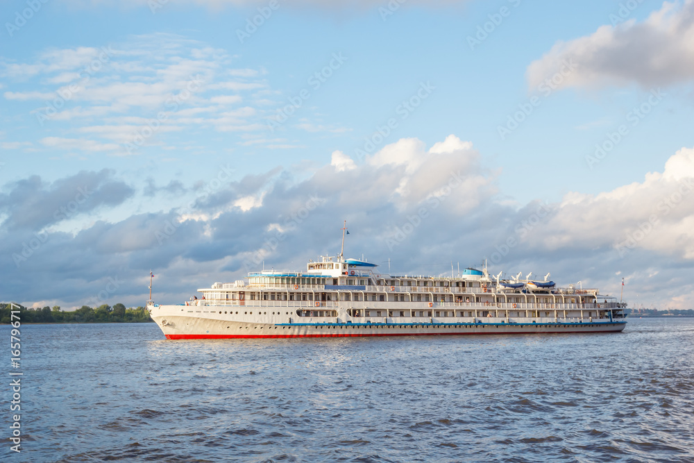 Cruise ship go along the Volga in the rays of the evening sun