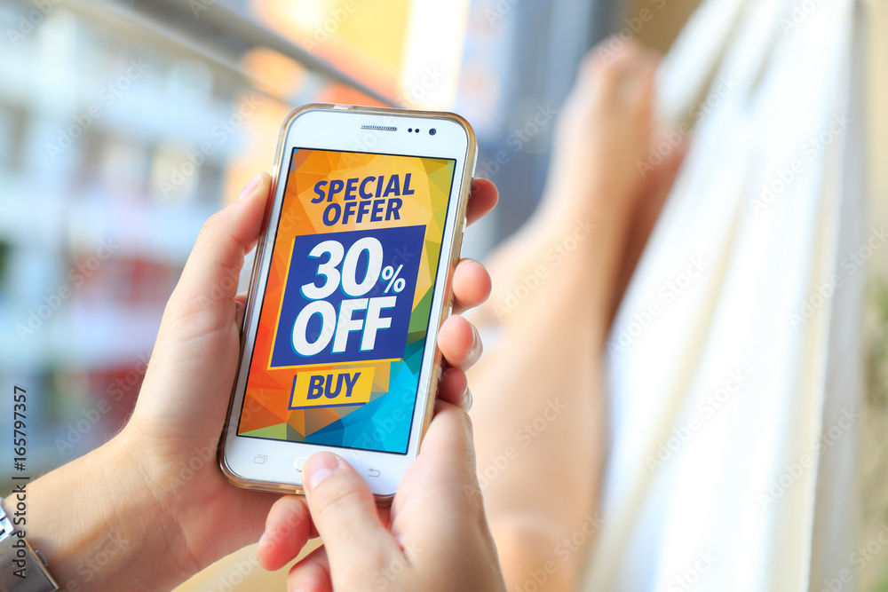 Woman in a hammock with a smartphone with a 30% OFF advertising on the screen. Marketing, ecommerce, discount, email marketing, cell phone publicity.