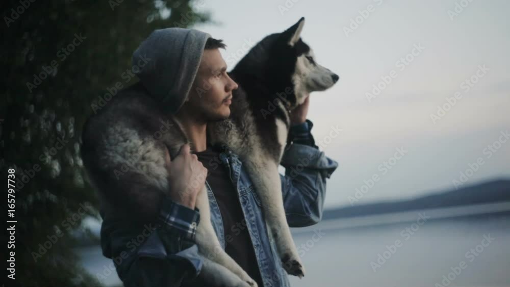 Man is holding a dog on his shoulders