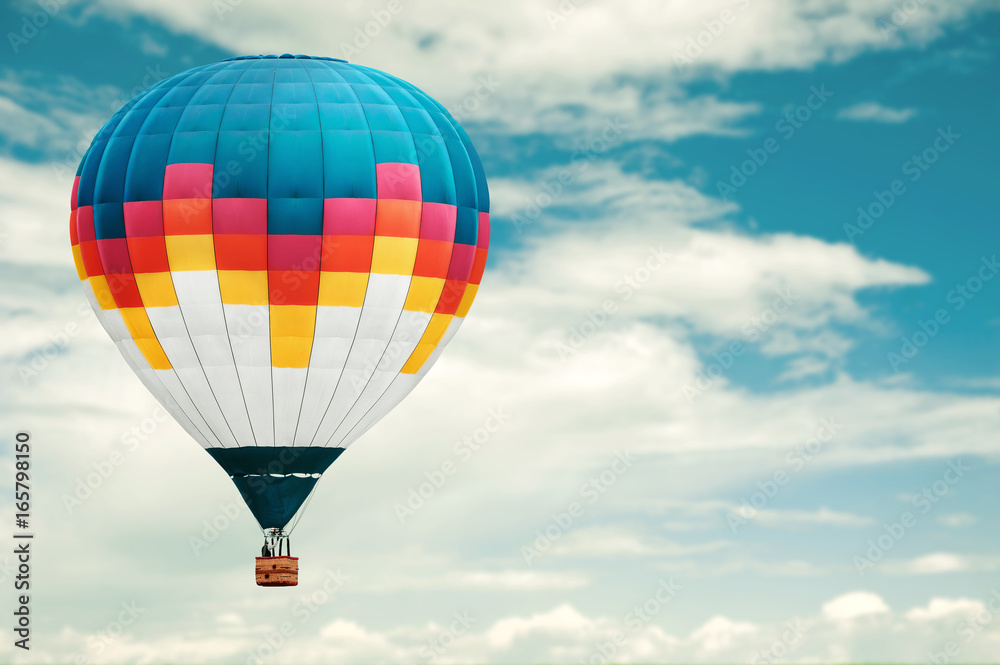 Fototapeta premium Colorful hot-air balloon against blue cloudy sky