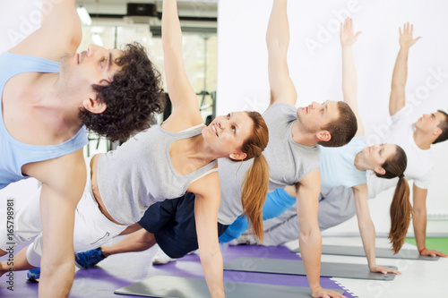 Group of people doing yoga exercise.